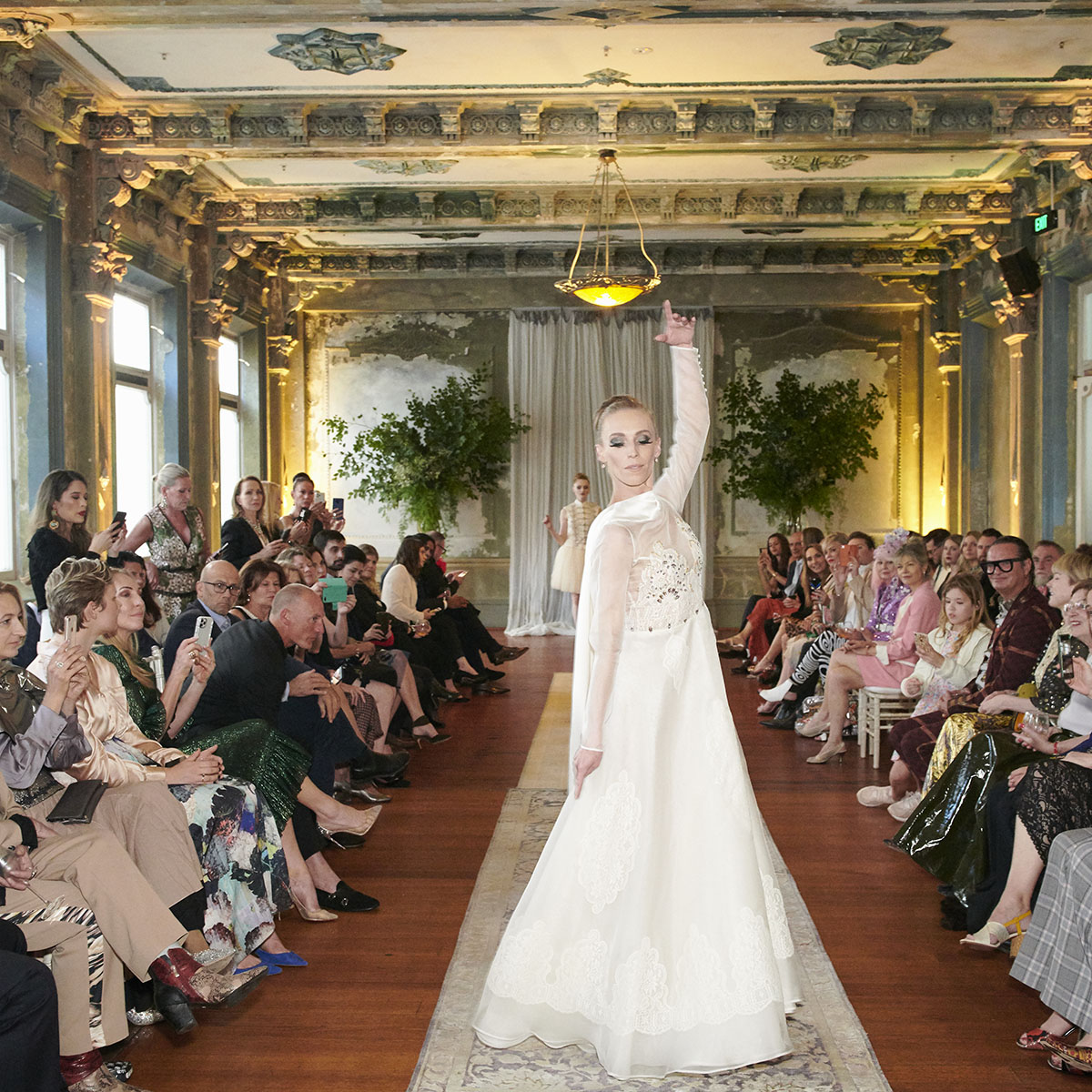 Composed of fine silk organza, this wedding dress is inspired by the light and enchantment of the magnificent crystal chandeliers that illuminate the Palais Garnier. Hand-stitched French lace has been used to create intricate motifs on the dress, while the long train is made of a heavy silk satin. - DELPHINE GENIN