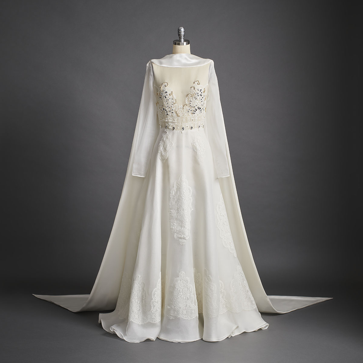 Composed of fine silk organza, this wedding dress is inspired by the light and enchantment of the magnificent crystal chandeliers that illuminate the Palais Garnier. Hand-stitched French lace has been used to create intricate motifs on the dress, while the long train is made of a heavy silk satin. - DELPHINE GENIN